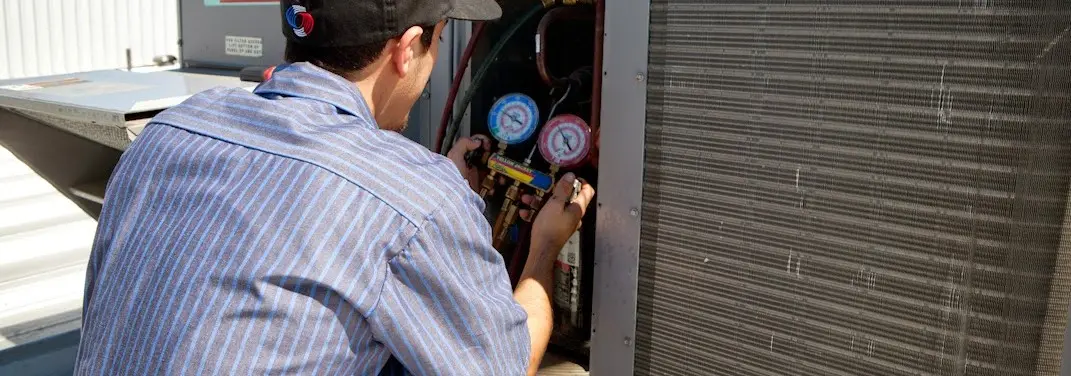 HVAC technician servicing a condenser unit in Cherry Valley