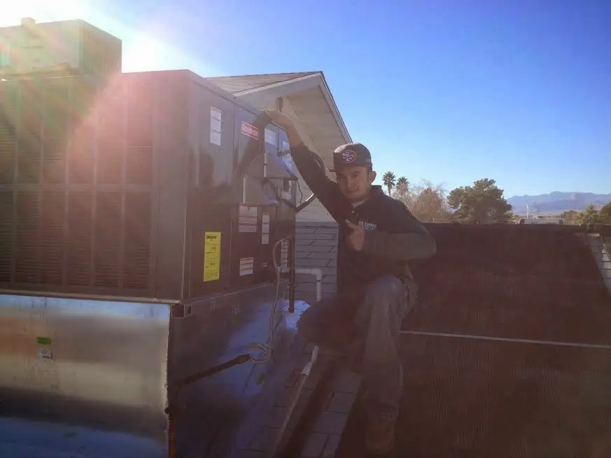 HVAC technician performing Air Duct Cleaning on a rooftop unit in Cherry Valley